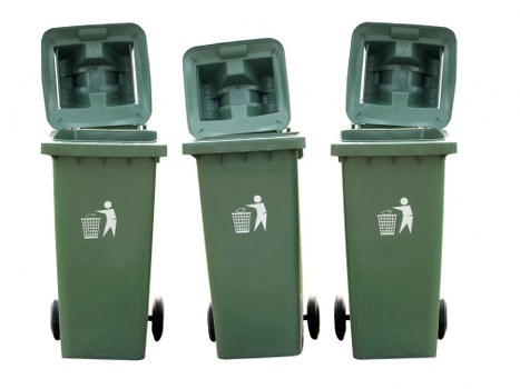 Three green wheeled rubbish bins with open lids positioned outdoors on a paved surface, set in a row with the middle bin slightly behind the other two. The bins are made of durable plastic with a textured finish, and each features a white pictogram of a person disposing of waste into a bin on the front. The background is plain white, emphasizing the organisational display of the bins, which are typically used for waste collection in commercial or residential settings. The scene suggests a context of waste disposal or collection, aligning with rubbish removal services provided by companies such as Commercial Waste Camberley, serving the local area near Camberley, Surrey, postcodes GU in Surrey. The arrangement indicates readiness for waste disposal or collection, and the open lids reveal the inner compartment of each bin, emphasizing ease of access for waste depositing. The overall scene presents a clean and professional image of waste management equipment used in urban environments, suitable for contexts such as commercial waste clearance or recycling services in Camberley and surrounding areas.