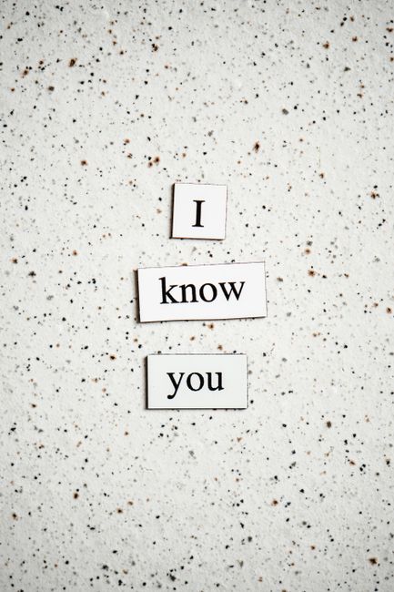 A light blue rectangular card with white text reading 'Don't worry. No one else knows what they're doing either.' is positioned on a white marble surface with grey veining. Surrounding the card are sc